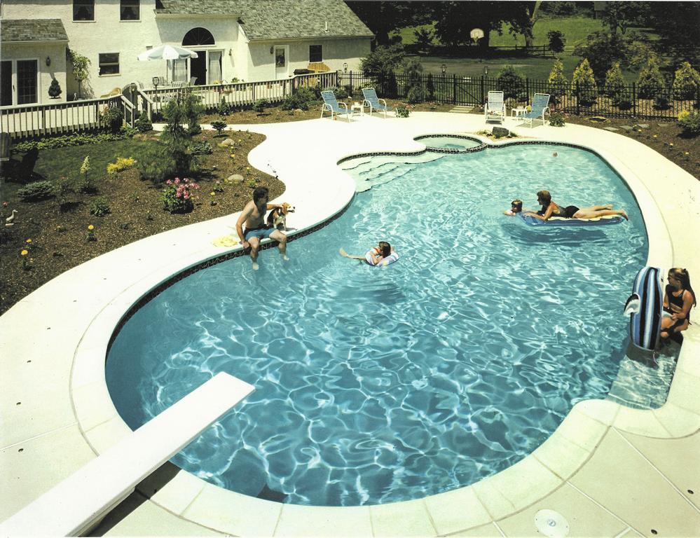 The pool with diving board in use from Anchor Backyard Pools & Spas Inc